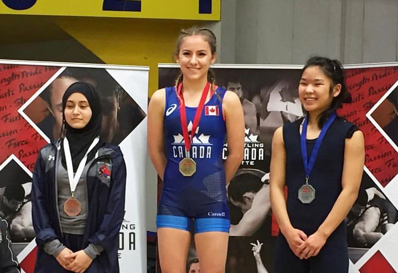 St. Thomas More's Caileen Corbett, centre, celebrates her win in the national juvenile 43kg freestyle wrestling championship last week in Windsor, Ont.