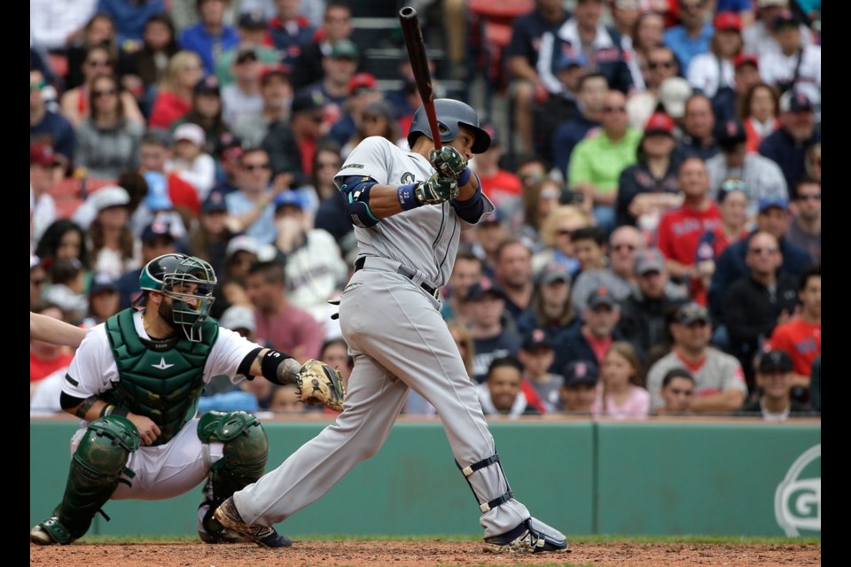 Seattle Mariners' Robinson Cano hits a two-run home run as Boston Red Sox's Sandy Leon looks on in the ninth inning of Sunday's game in Boston.