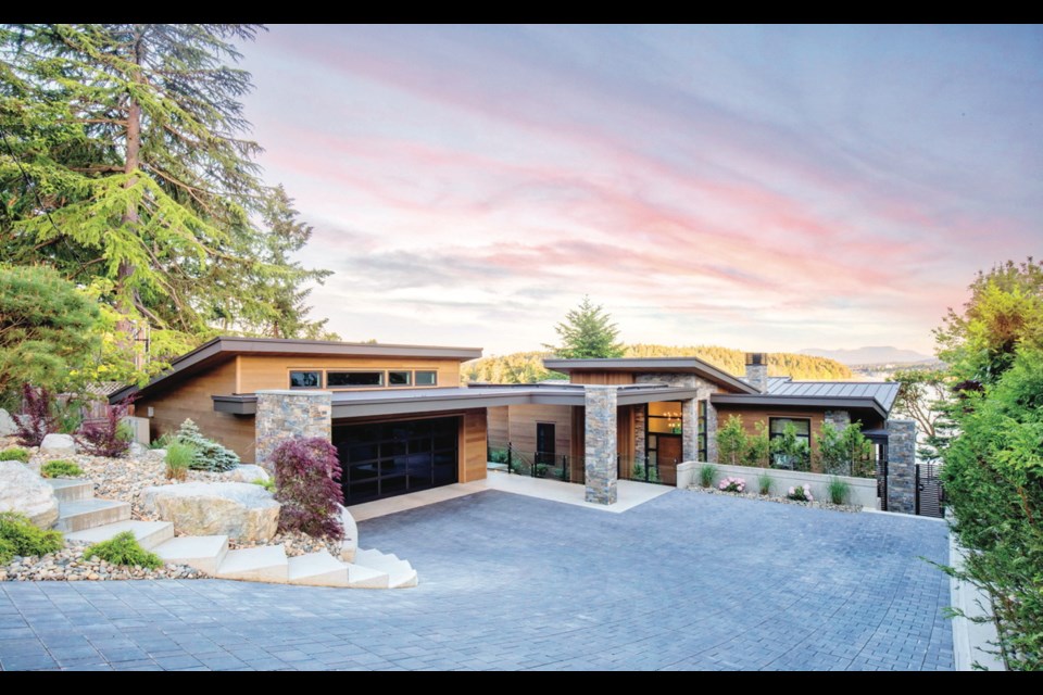 The garage has a vaulted ceiling and clerestory windows. The home&rsquo;s redesigned entry includes a roofline that tilts up to greet visitors, a small retaining wall and a glass railing. The exterior finish is natural rock from K2 Stone, and cedar siding.