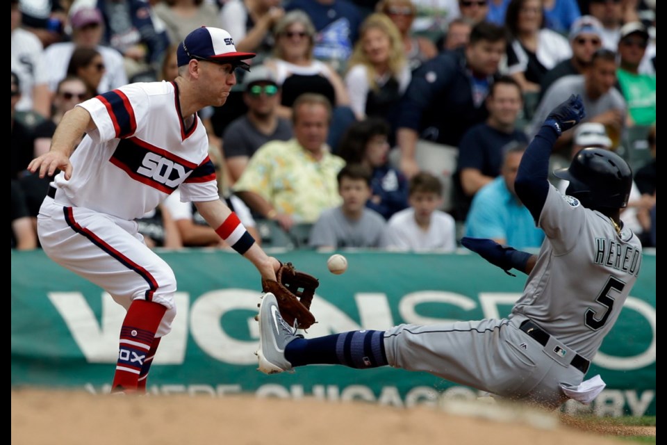 Seattle Mariners' Guillermo Heredia, right, is safe at third as Chicago White Sox third baseman Todd Frazier tries to catch the ball during the sixth inning of Sunday's game in Chicago. Heredia advanced to third on a throwing error by White Sox center fielder Alan Hanson.