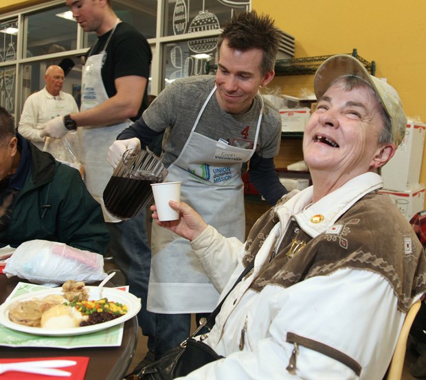 A Union Gospel Mission volunteer fills Valerie Blais's cup up with juice at Feed the Homeless for Christmas, Dec. 8.