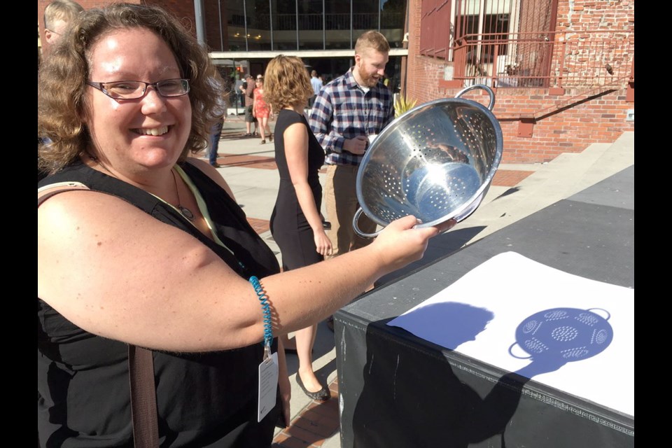 Stephanie Blaizey used a metal colander to watch the eclipse through a pattern of shadows cast onto white poster board. She said her dad gave her the idea.