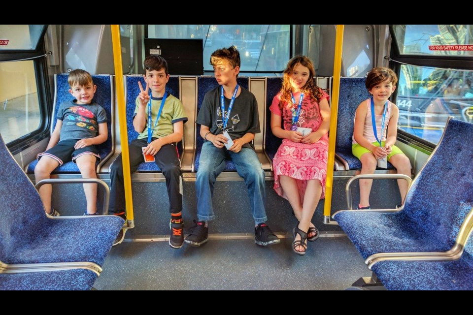 The kids (including the littlest one), chilling at the back of the bus, on our way to English Bay.