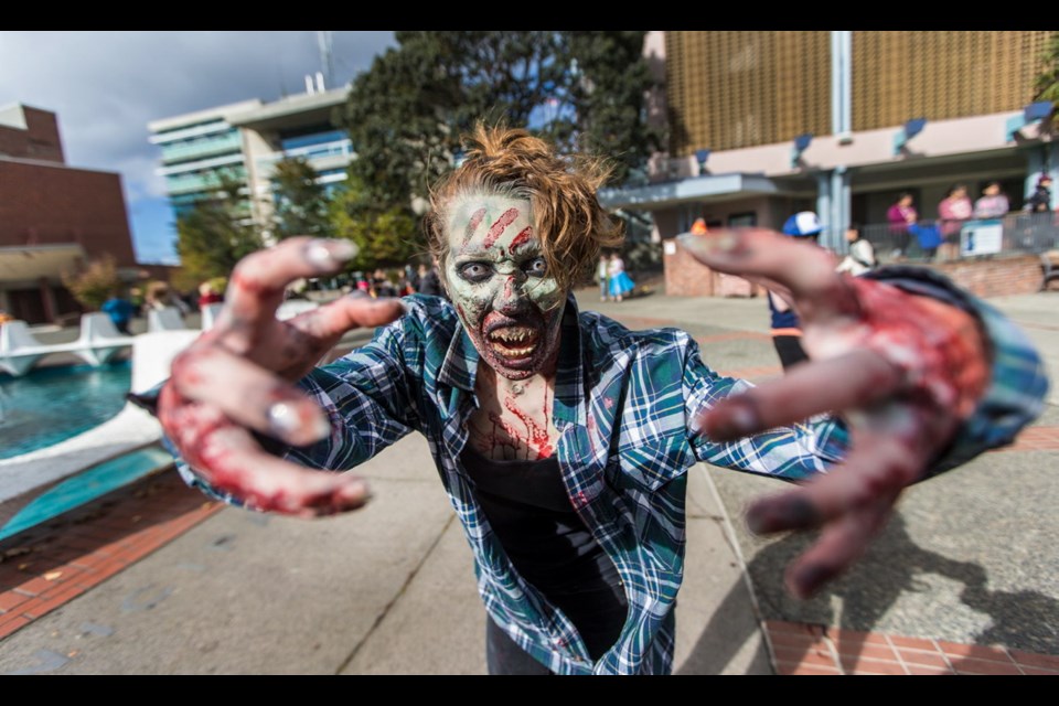 Playing dead came naturally to participants such as Evelyn Jordan, whose antics attracted a crowd of photographers at the start of the Victoria Zombie Walk in Centennial Square.