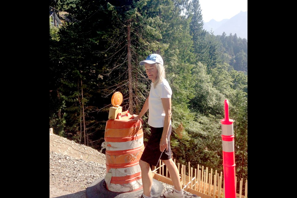 Carol Fancy lived for a time in the Eaglecliff area, and walked almost daily, rain or shine, to the Cove and back. Here she is standing by a construction site on particularly dangerous corner of Eaglecliff Rd.