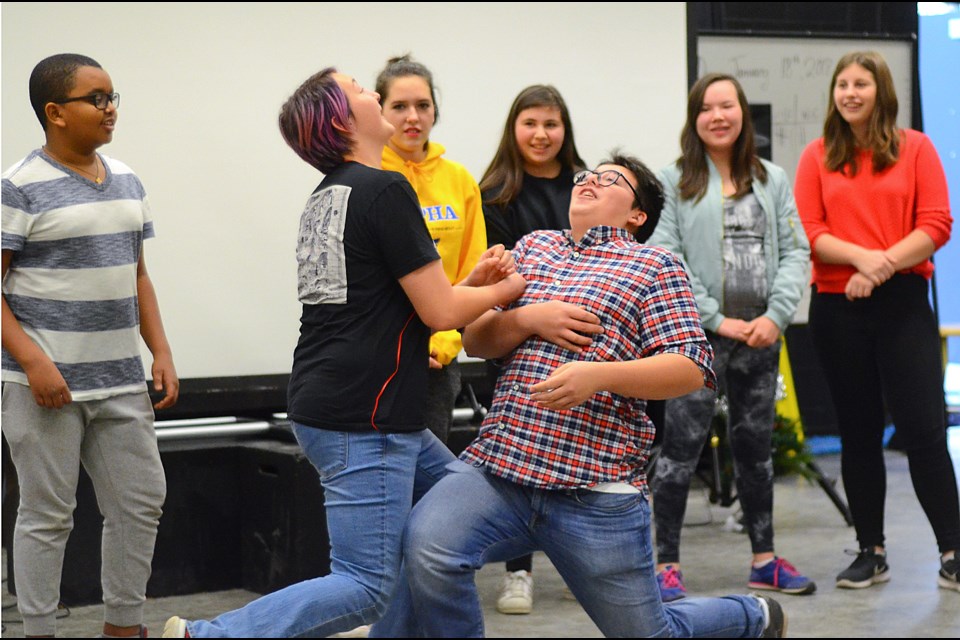 Alpha Secondary School improv club members Johanna Coley and Quinten Silcox act out a scene while fellow club members look on at a recent performance in the school’s drama room.