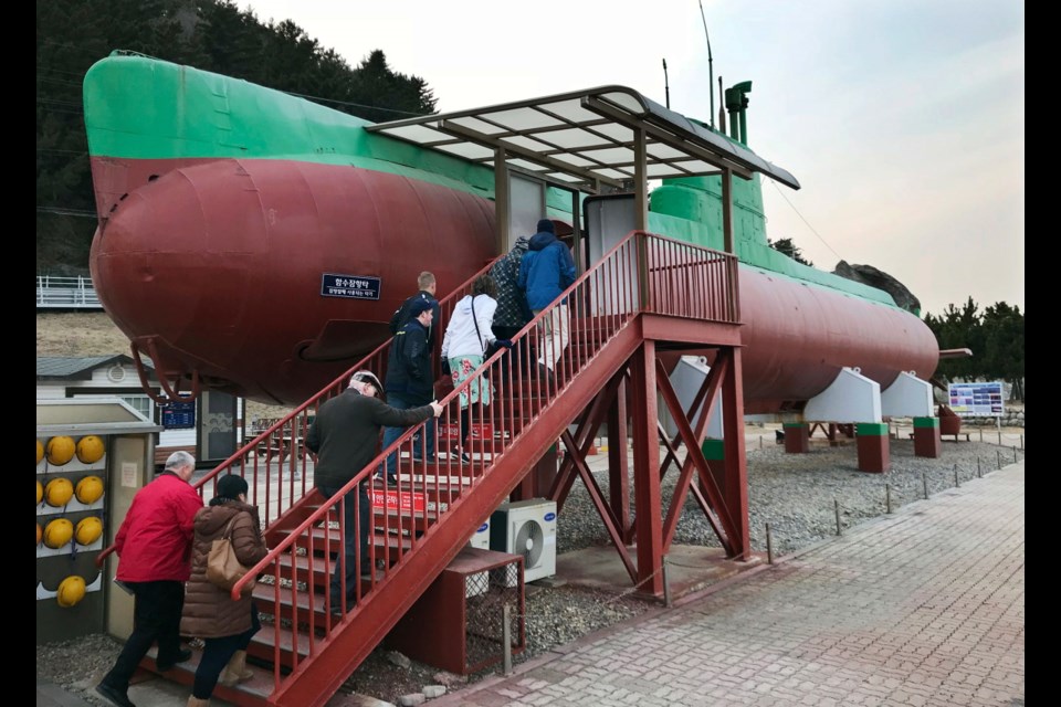 In this Sunday, Feb. 18, 2018 photo, visitors board a North Korean submarine on display at the seaside "Unification Park" in Gangneung, South Korea, where the Olympic skating, hockey and curling events are held. The submarine ran aground during a 1996 espionage mission. The crew members abandoned the vessel and went into nearby rugged, heavily wooded mountains triggering a manhunt by South Korean authorities.