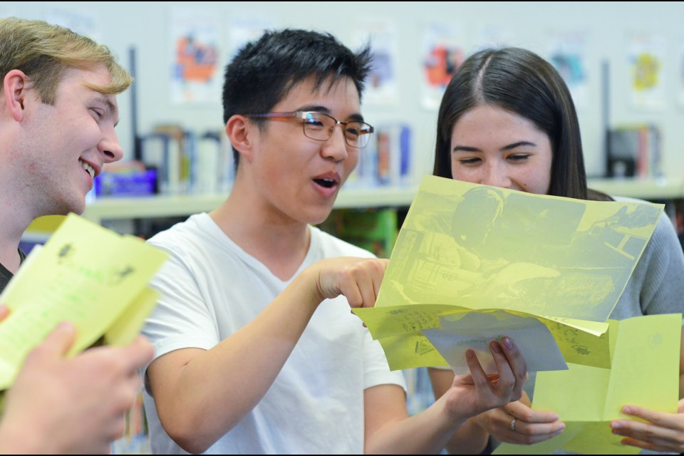 From left, former Seaforth Elementary students Aidan Maddalozzo, Antony Shiu and Mei Doerksen read letters they wrote to themselves in Grade 3. Members of teacher Lynda Glavas's 2006/07 class reunited at Seaforth on June 18 to open a time capsule they sealed 11 years ago.