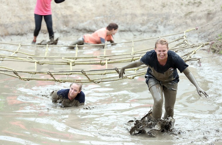 Participants crawl through mud in one of the eighteen obstacles on Saturday during the Mudd, Sweat, and Tears obstacle course race at Otway Nordic Centre. Citizen Photo by James Doyle