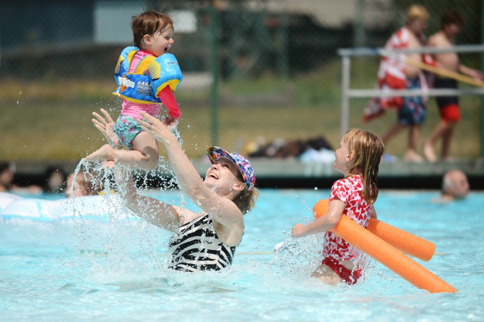 Two-year-old Briar Bygraves gets a lift from Margot Byrom as five-year-old Elizabeth Burns looks on. Photo Jennifer Gauthier.