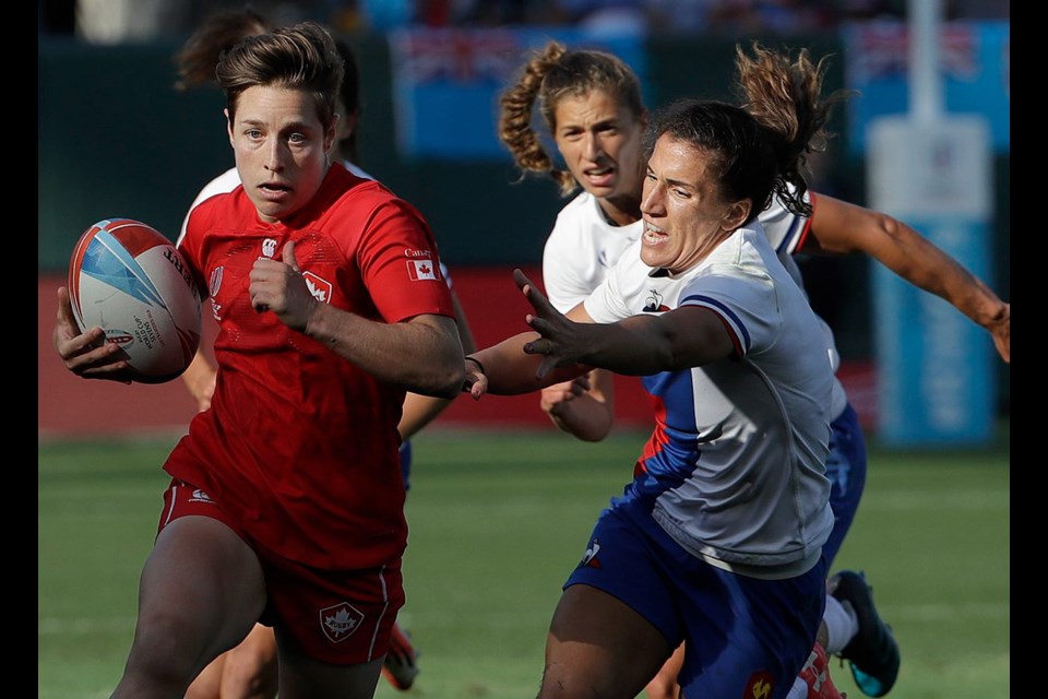 saʴý's Ghislaine Landry, left, runs past France players during the Women's Rugby Sevens World Cup in San Francisco, Friday, July 20, 2018.