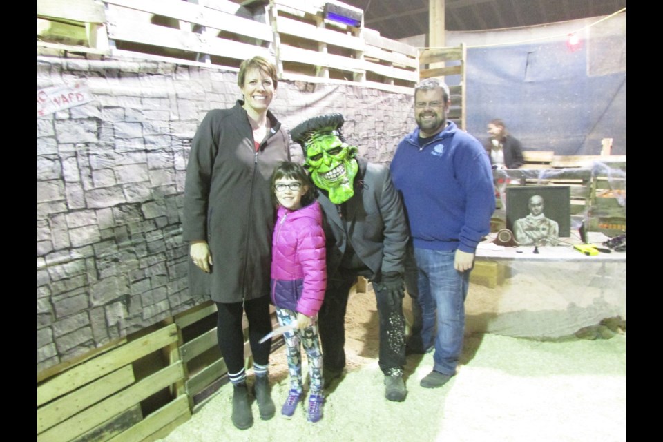 Jennifer Cole, with daughter Erica, 7, and Erica's dad, Matt Hutcheon, posed for a photo with Frankenstein, Tyler Sylte, since Frankenstein was Erica's favourite character she met during the third annual Haunted Maze held in the 4-H Barn on the exhibition grounds during the family-friendly version of the event.