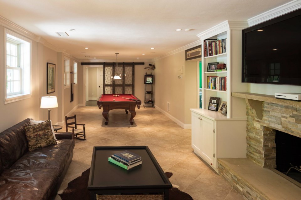 A sliding barn door made mainly of glass, used here in a media/game room, allows the homeowner to close off the space but still retain a flow of natural light and a connection to other rooms.