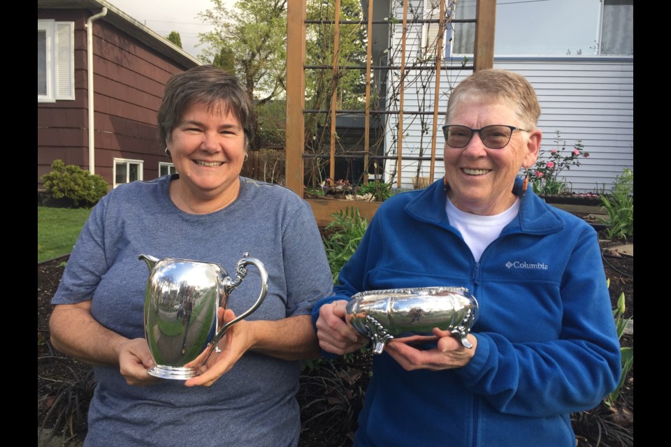 Diane Perry, left, and Audrey Barnes of the New Westminster Horticultural Society show off two of the trophies once given out to winners at the club’s flower shows.