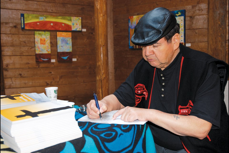 Stan Dixon signs copies of his book, K’watamus Speaks Book 1, in May of 2009. The shíshálh elder died last week at the age of 77.