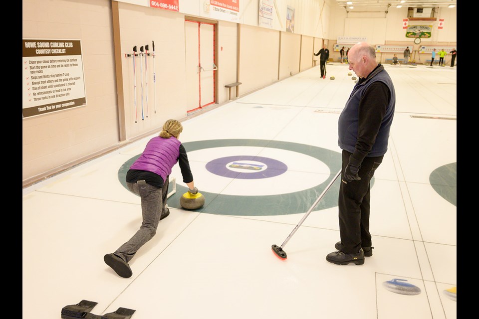 First time curler Kathy Malvern gets some instruction from Ken Taylor.