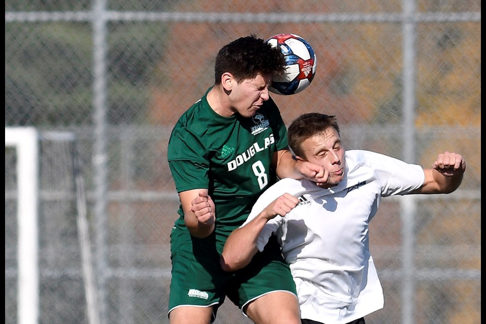 It's all up in the air, as Douglas College's Quinn Desaulniers, at left, gets his head on the ball ahead of Vancouver Island's Griffin Douglas during their PacWest men's soccer final Saturday in Burnaby.