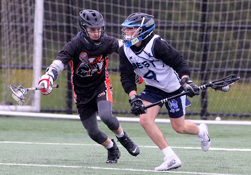 MARIO BARTEL/THE TRI-CITY NEWS
Ryan Favaro, of the Dr.Charles Best Blue Devils, tries to escape the check of the New West Hyacks defender in the first half of their senior Tier 1 game at the BC High School Lacrosse provincial championships, Monday at Coquitlam's Town Centre park. Best won, 10-8. The tournament concludes on Thursday.