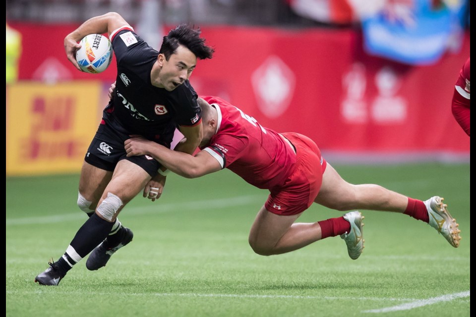 Canadian co-captain Nathan Hirayama, left, is tackled by Wales&Otilde; Will Jones during the saʴý Sevens rugby tournament in Vancouver on Saturday. saʴý won 29-7 and went 3-0 on the first day of pool play.