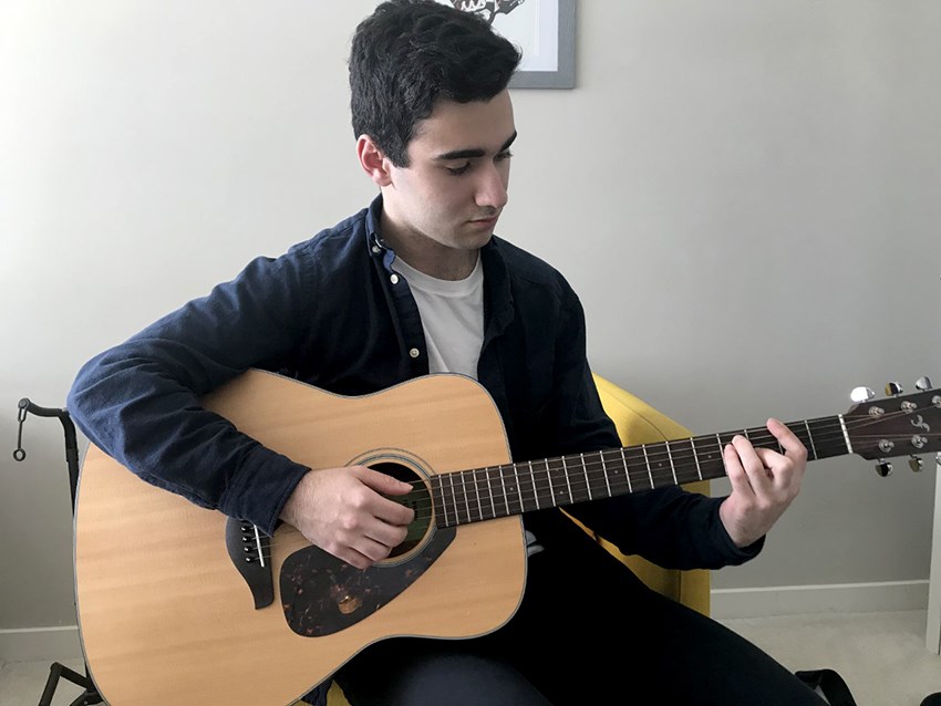 Student practices guitar during COVID-19 quarantine