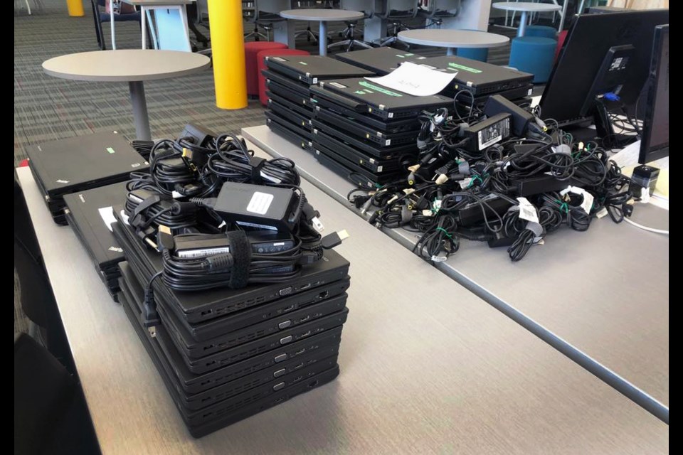 Stacks of laptops are ready to be loaned out at a school district site.