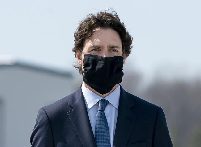 Prime Minister Justin Trudeau wears a mask at a repatriation ceremony for the six Canadian Armed Forces members killed in a helicopter crash off of Greece during Operation Reassurance, at CFB Trenton, Ont. on Wednesday, May 6, 2020. Trudeau says a national recommendation on when and where Canadians should be wearing face masks is coming later today. THE CANADIAN PRESS/Frank Gunn