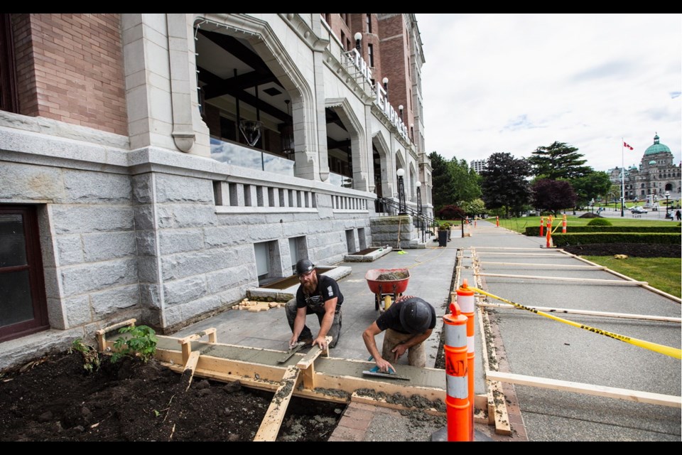 Mike Johnson, left, and Taylor Richens of Sawyer Construction work on expanding the front patio of the Fairmont Empress Hotel.