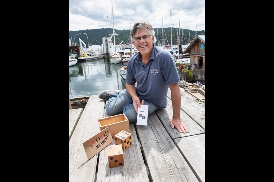 John Denny at Portside Marina with the COVID-19 game, played with wooden dice, that he created. He is donating 50 per cent of the selling price to the Victoria Foundation. June 2020