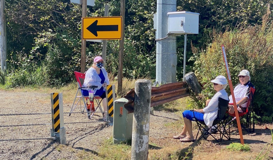 A person from Washington State meeting two Canadians at the western end of the new U.S. border fence.