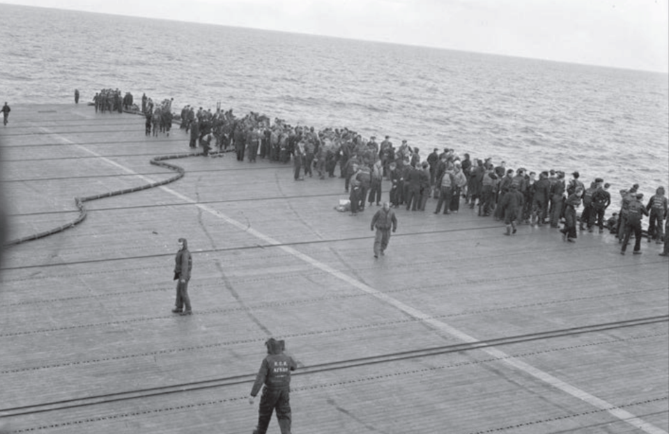 Crew of the H.M.S. Nabob line the deck following a torpedo attack in the Arctic waters off Norway, A