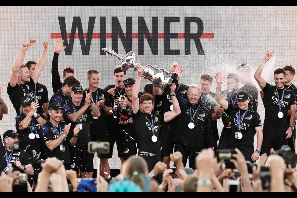 Emirates Team New Zealand helmsman Peter Burling holds the America's Cup trophy aloft after defeating Italy's Luna Rossa in race 10 of the America's Cup on Auckland's Waitemata Harbour, Wednesday, March 17, 2021. Team New Zealand has retained the America's Cup by beating Italian challenger Luna Rossa 7-3 in the 36th match for sailing's oldest trophy. (Alan Lee/Photosport via AP)