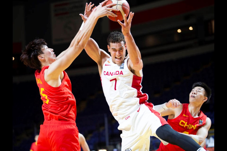 saʴý’s Dwight Powell goes for a rebound against China’s Qi Zhou, left, and Zhenlin Zhang in FIBA Olympic Qualifying Tournament action at Save-on-Foods Memorial Centre on Wednesday, June 30, 2021. DARREN STONE, TIMES COLONIST