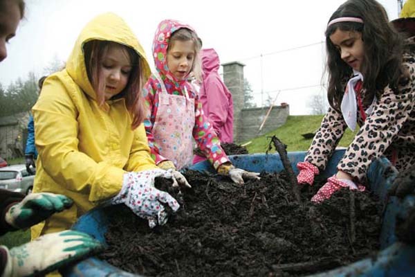 Getting ready: Graycee Koebel, Katharine Galloway and Ilana Gastaldo help out at a tree planting event at Queen's Park on March 10. Members of the 9th New Westminster Brownies planted trees at the new turf field at Queen's Park on March 10 to raise awareness about environmental stewardship.