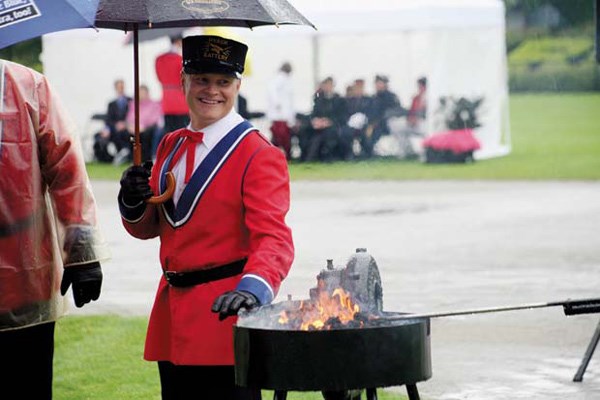 Staying dry: Mark Stevens, Hyack Anvil Battery team member, takes shelter from the weather for the Ancient and Honourable Hyack Anvil Battery salute at Queen's Park Stadium.