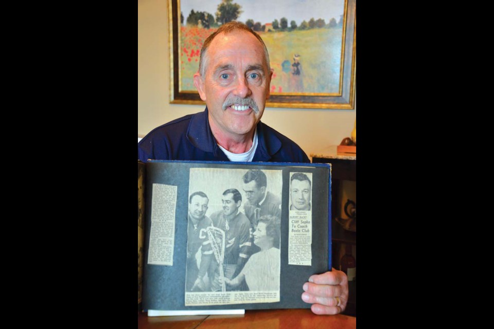 Looking back: Wayne Goss shows off a 40-year-old newspaper article in which he was featured. Goss is in the centre of the picture he's displaying.