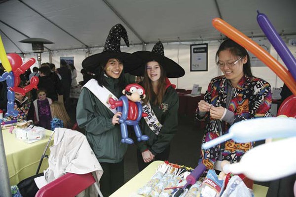 In the spirit: Alisa Too (Miss Hyack princess), Brooke Moore (Hyack ambassador) and Ling Wang made balloon figures at the opening of the Brewery District development in Sapperton on Saturday. The grand opening featured giveaways, music, treats and activities for kids.