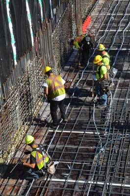 Men and women at work: Crews work on the parkade structure at the future multiuse civic facility and office tower, which is now being built at Columbia and Eighth streets.