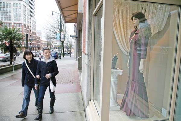 Window shop: Passersby take a look at a window display at one of the wedding dress shops on Columbia Street in downtown New Westminster.