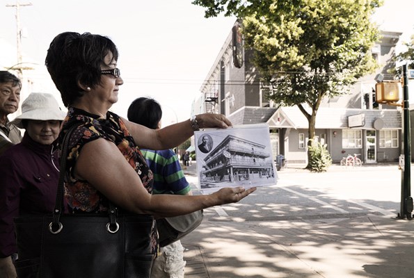 Linda Kawamoto Reid holds up a photograph of the Secord Hotel that was located at 401 Powell Street during the Historic Japantown Walking Tour Saturday, July 20, 2013.