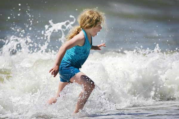 Kalea Edmison runs from the large surf at Ambleside.