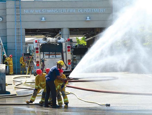 Water works: A trio of teens participating in the 2013 youth firefighter program try their hand at handling a fire hose. The students trained at the Queensborough fire hall and the Justice Institute of B.C. campus in Maple Ridge during the July 2 to 7 program.