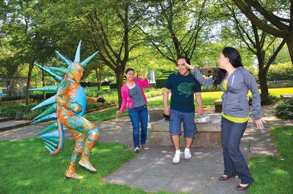 Ruchelle Bamboo, David Cabanas and Andrea Gonzalez get down with Walla-Walla Blink Blink, a lizard of the shiny variety, at Summer Sundays in Burnaby's Civic Square.