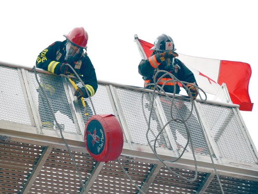 District of North Vancouver firefighter Carla King Penman (left) hoists a weight up a tower during the FireFit nationals held this summer in Edmonton. Penman and fellow DNV member Matt Ciolfi finished first in the mixed tandem competition and will compete at the world championships Oct. 22-27 in Las Vegas. Photo Supplied