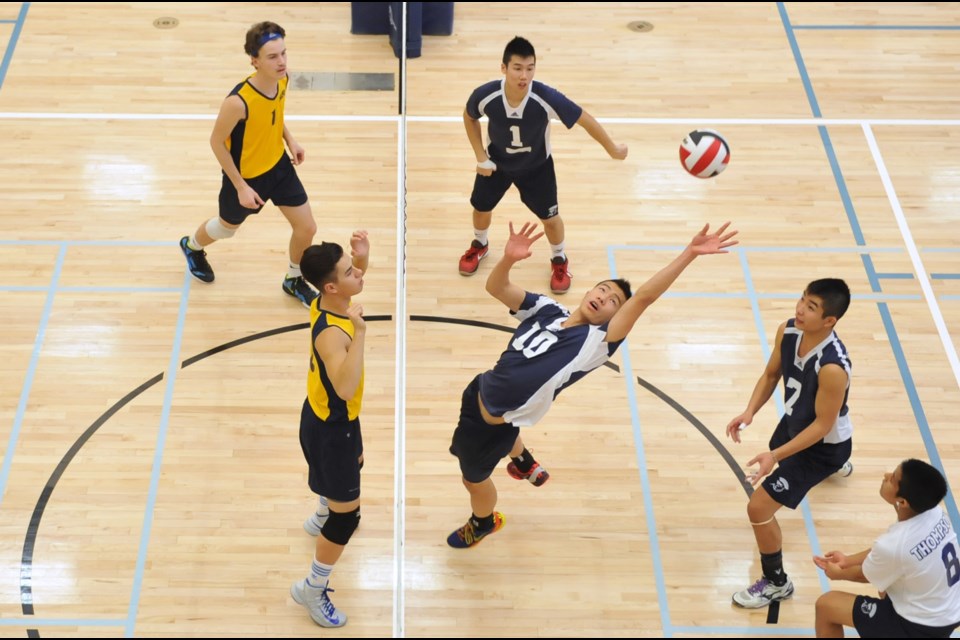 David Thompson middle blocker Brandon Lam reaches back on an errant tip at the senior boys AAA volleyball championships against Belmont Nov. 29 at UBC Okanagan.