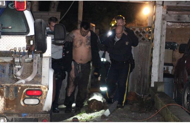 A suspect under arrest in a ravine behind a home in the 10900-block of 132A Street in Surrey.