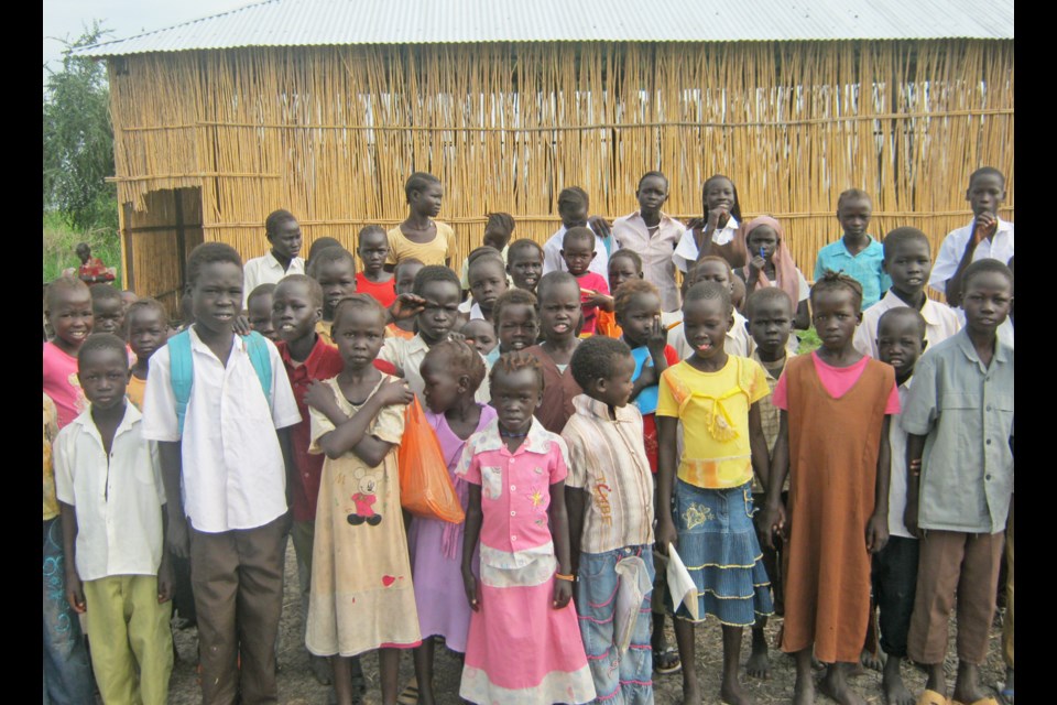 Peace: Students from the village of Nyongrial in South Sudan stand in front of the school built for them by the Padang Lutheran Relief Society in 2010. The school has since been destroyed in a civil war between the government of South Sudan and rebel and military forces.