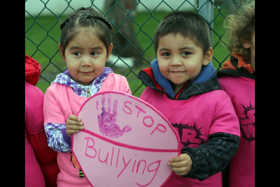 Agnes Charles, 3, and Gordy Goldsmith, 3, hold a sign as children from the Songhees First Nation Daycare and Pre-school take part in anti-bullying rally, wearing the campaign's signature pink colours.