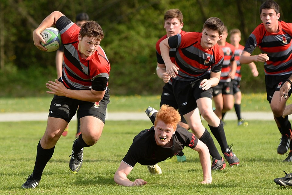 Lord Byng's Curtis Delmonico powers ahead of Magee tackler Callum Botchar in the senior boys rugby city championship at Camosun Park on May 1. Lord Byng beat Magee 59-17.