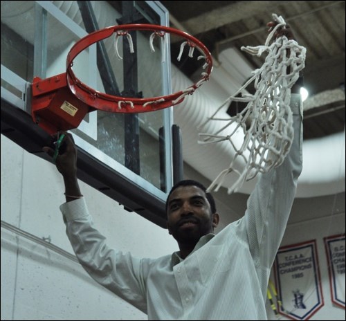 Head coach Dany Charlery cuts down the mesh.