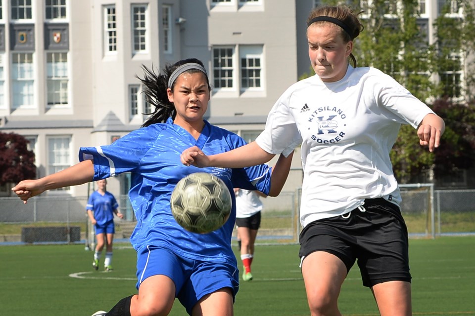 Point Grey's Kai Vorland (left) and Kitsilano captain Huntley Bain compete for a free ball in the senior girls soccer city championship at Point Grey secondary on May 6, 2014.